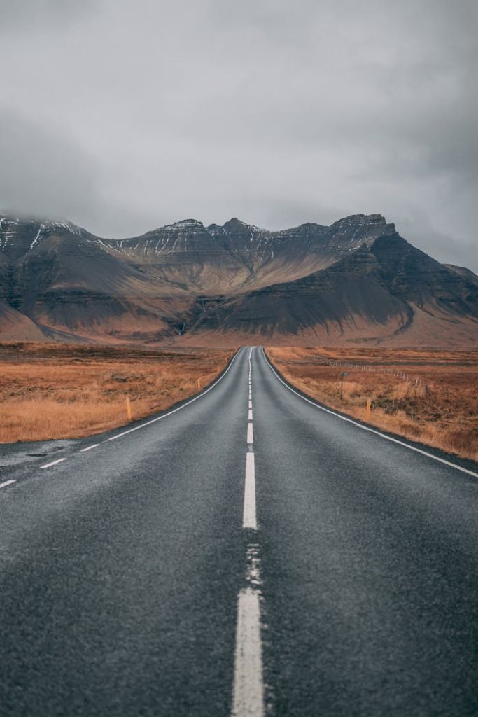 empty-highway-overlooking-mountain-under-dark-skies-1955134 A scenic empty road stretches into snow-capped mountains under cloudy skies, offering a sense of adventure and tranquility.